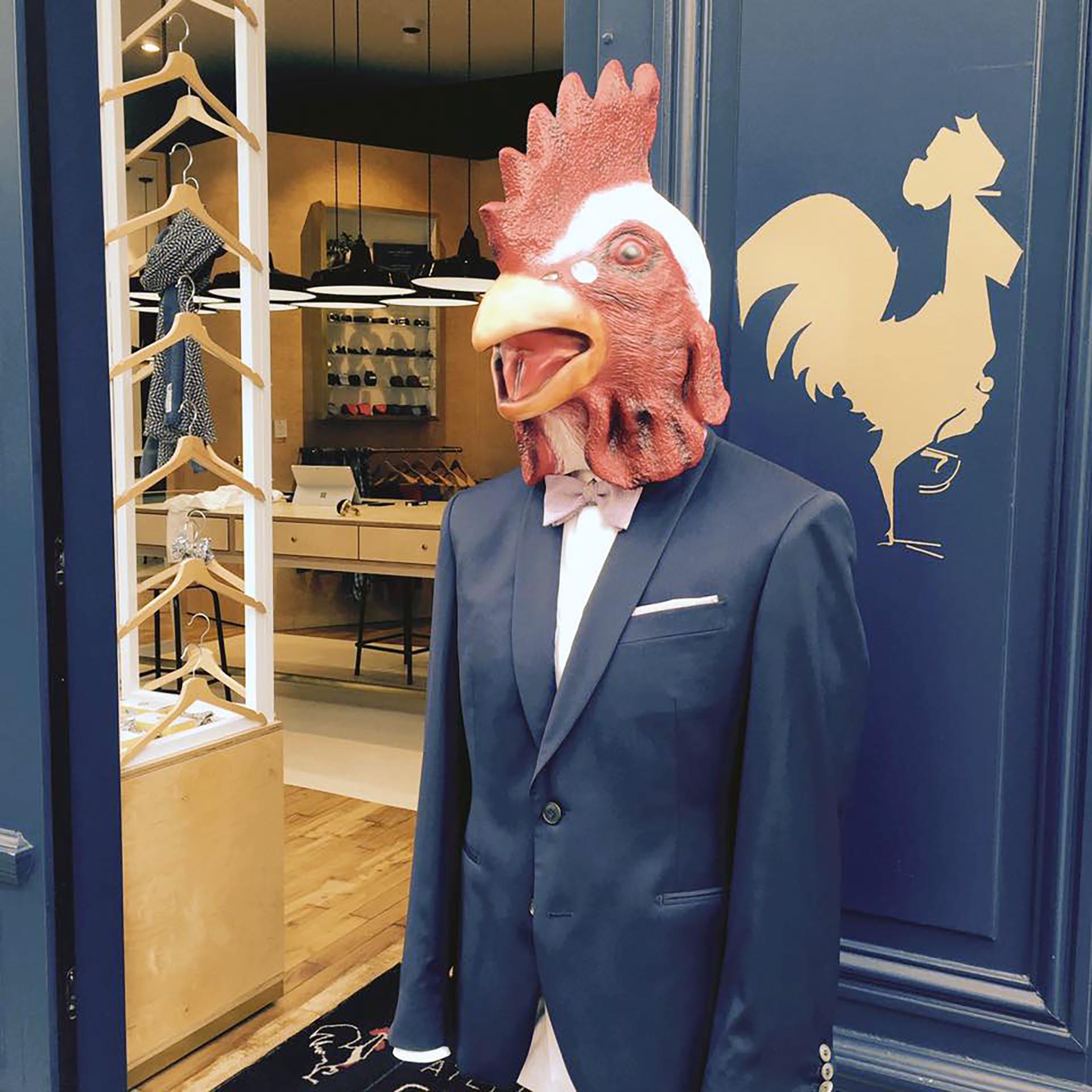 Décor de Noël peint sur la vitrine d’Atelier Coqlico avec coq élégant et sapins stylisés