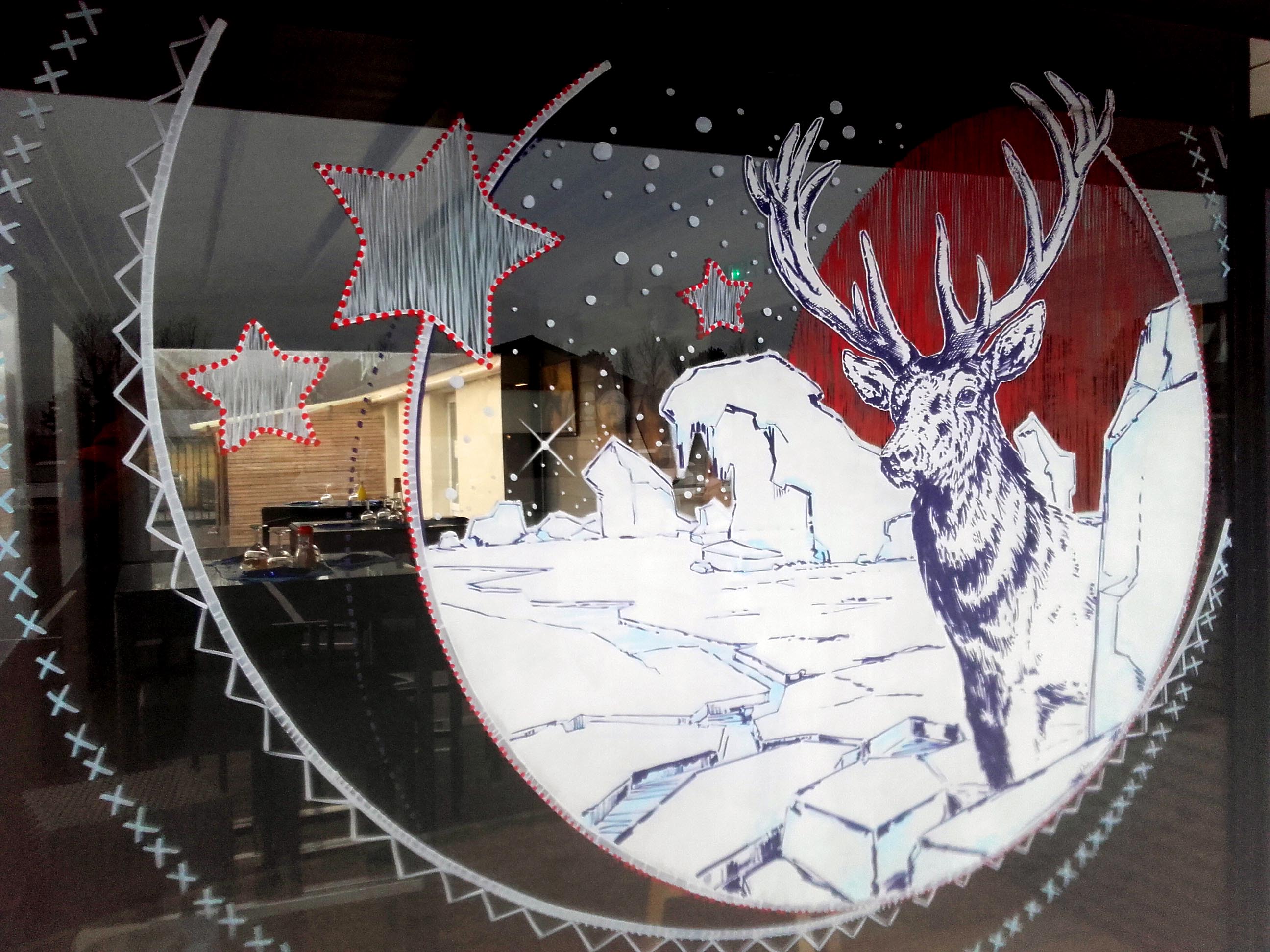 Peinture sur vitrine hivernale nordique avec cerf majestueux pour La Cave à Huître à Caen