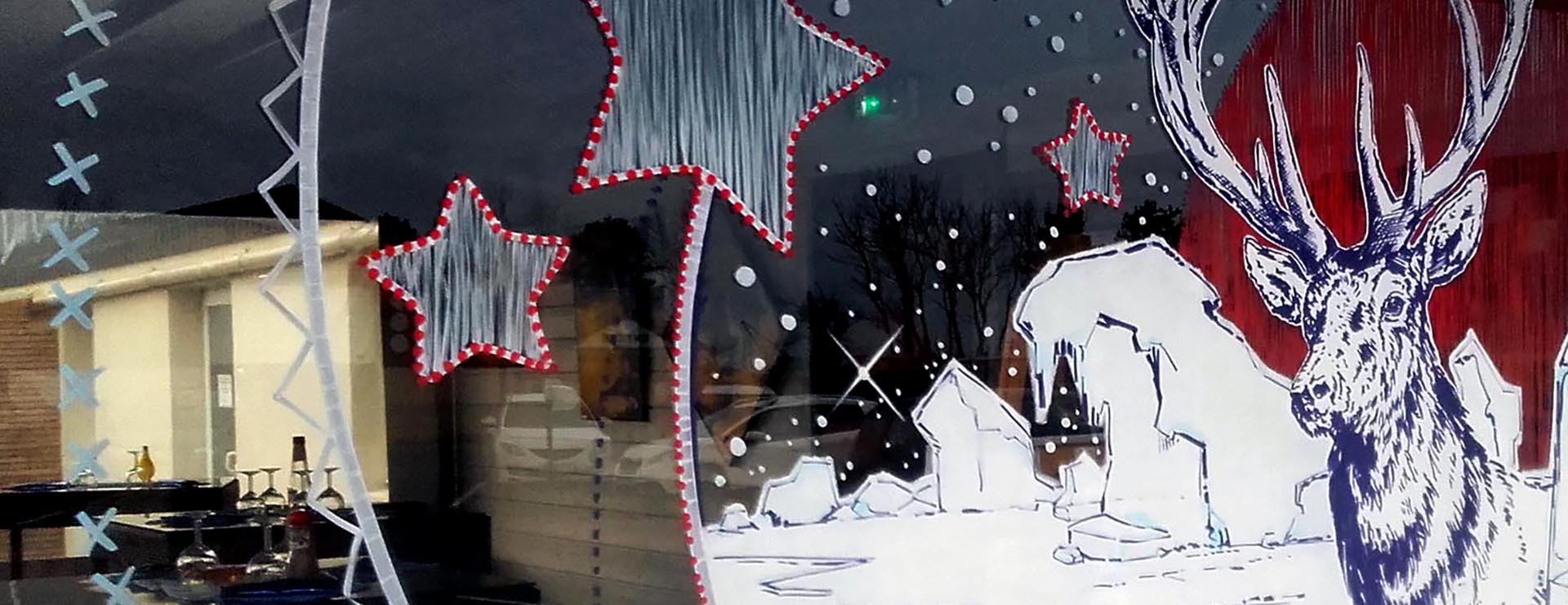 Peinture sur vitrine hivernale nordique avec cerf majestueux pour La Cave à Huître à Caen