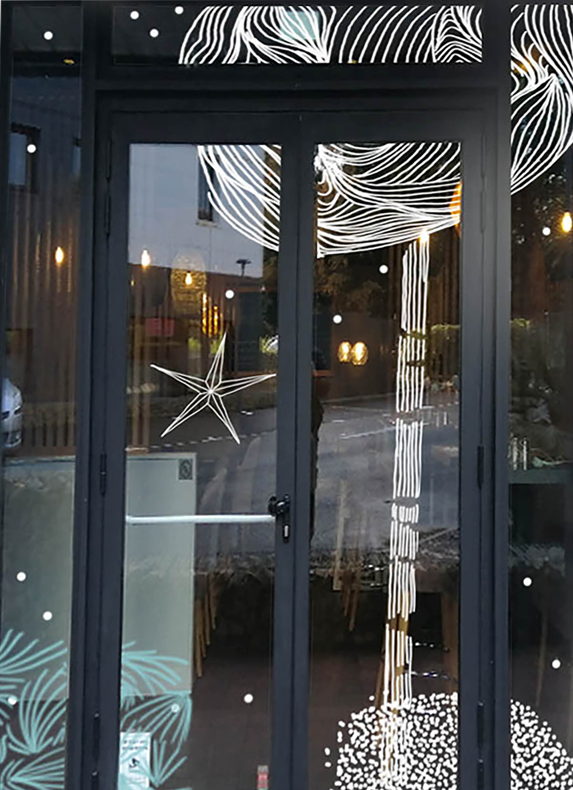 Décor de vitrine de Noël avec arbres stylisés blancs et motifs hivernaux.