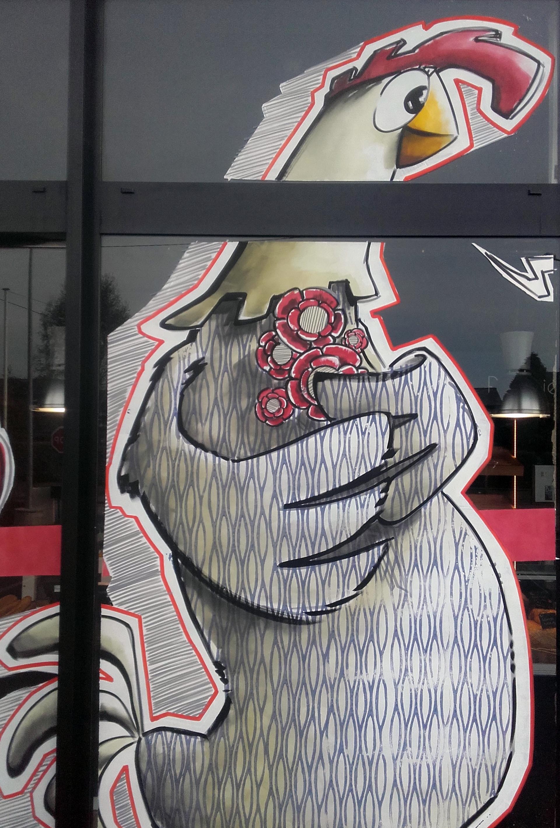 Peinture sur vitrine de Pâques par Jean‑Charles Varlet, poule stylisée et fleurs rouges.
